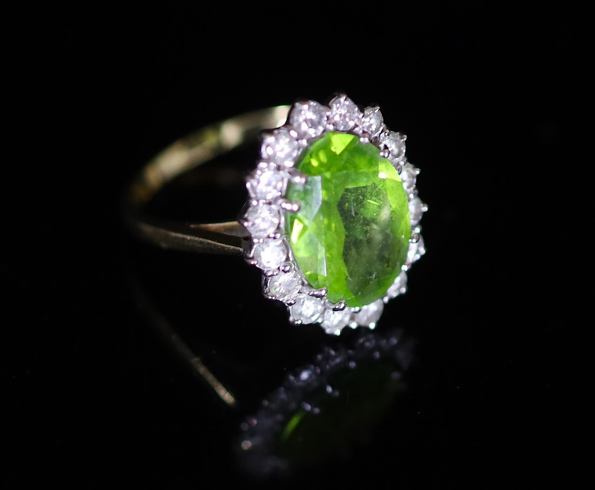 A modern 18ct gold, peridot and diamond set oval cluster ring